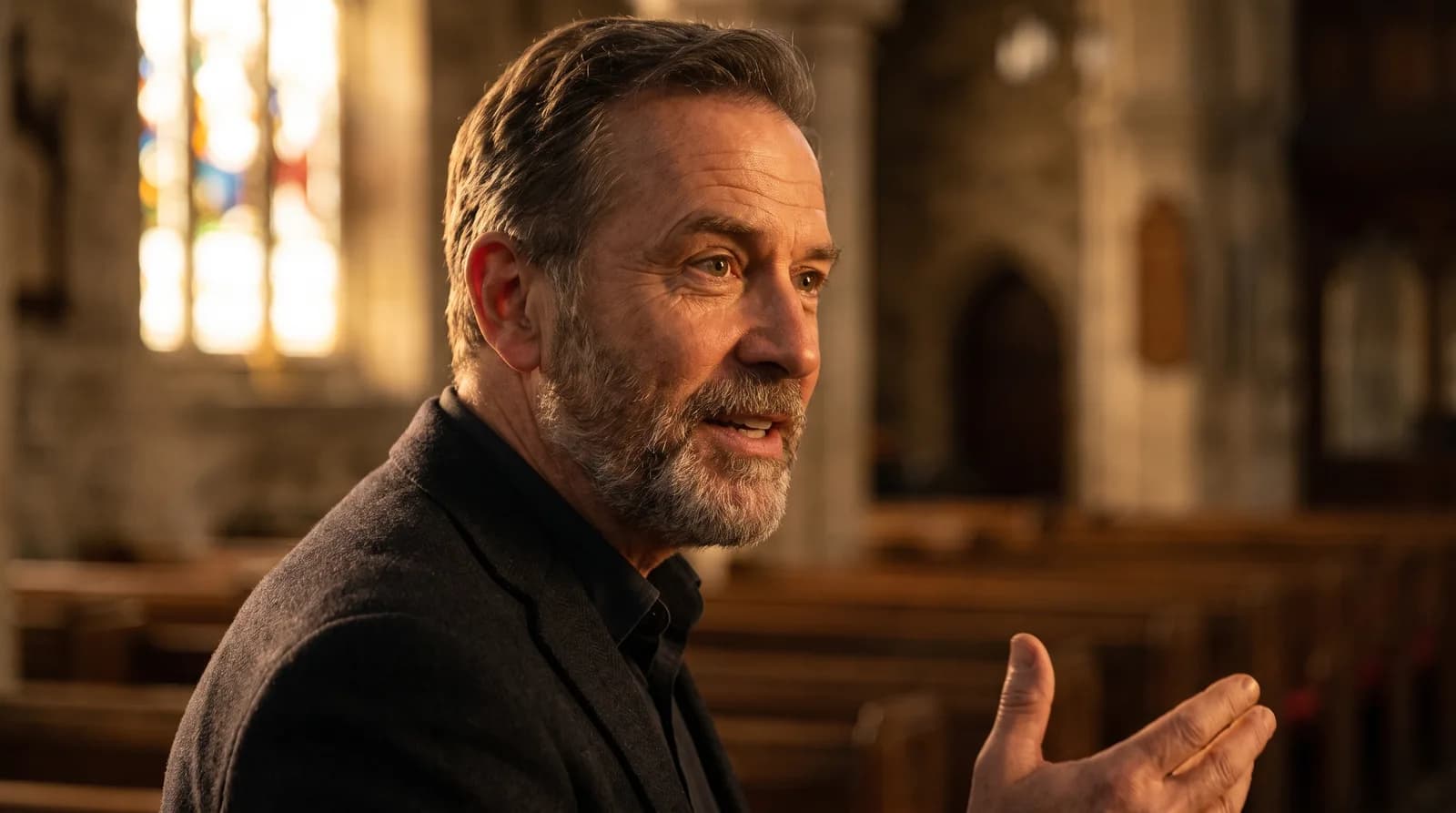 A calm, warm portrait of a host mid-sermon speaking with conviction in a church setting
