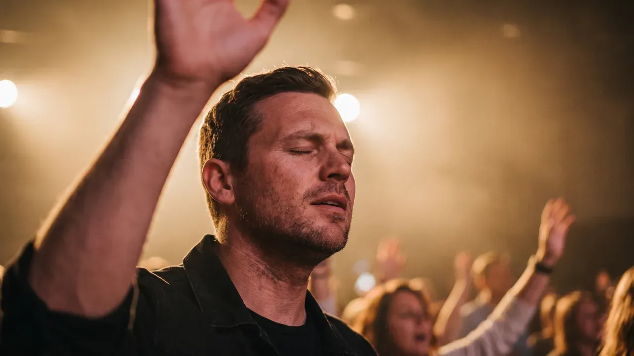 AI-generated thumbnail: a worship leader with eyes closed and hands raised on a warm stage, a blurred crowd with raised hands