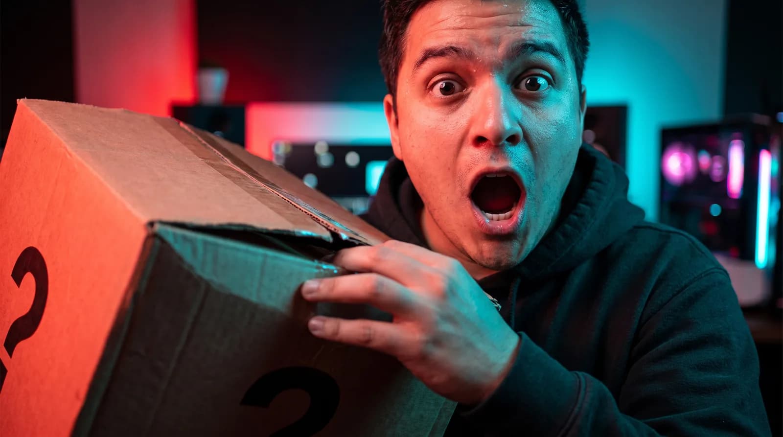 A creator with a shocked expression opening a giant mystery box on camera